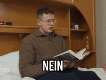 a man sitting on a bed reading a book with the word nein on his face