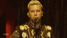 a man is singing into a microphone on a stage .