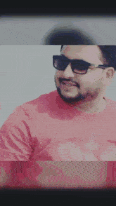 a man with a beard and sunglasses is wearing a red shirt