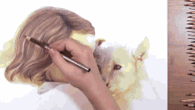 a person is drawing a cat with a pencil on a piece of paper