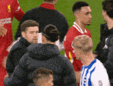 a group of soccer players with one wearing a red jersey that says standard chartered on it