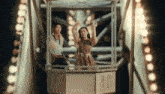 a man and a woman are riding a ferris wheel with the number 16 on it