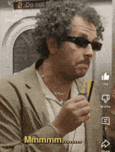 a man wearing sunglasses holds a credit card and says " mmmmm "