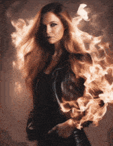 a woman in a black leather jacket is surrounded by fire