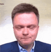 a man in a suit and blue shirt is making a funny face with his eyes closed