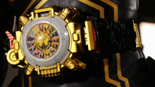 a gold and black watch with a zodiac sign on the face shows the time as 10:10