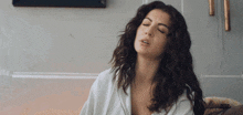 a woman with her eyes closed is wearing a white shirt
