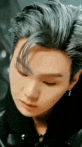 a close up of a person 's face with their eyes closed and their hair blowing in the wind .