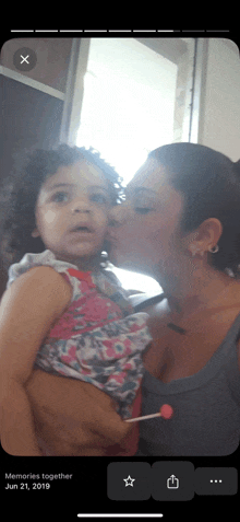 a woman is kissing a little girl on the cheek in a photo taken on june 21st 2019