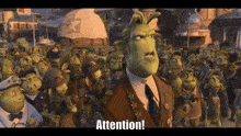 a man in a suit and tie stands in front of a crowd and says attention