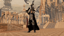 a man in armor holds a sword over his head in front of a building