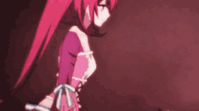a girl with red hair and a pink dress is standing in a dark room .
