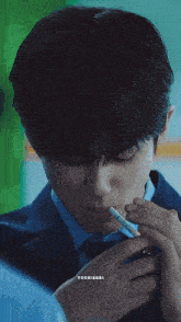 a man in a suit and tie is smoking a cigarette with tooxiaoqi written below him