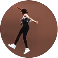 a woman in a striped top and black pants is dancing