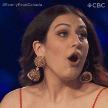 a close up of a woman 's face with her mouth open and the words family feud canada behind her