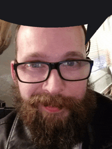 a man with glasses and a beard is wearing a black leather jacket