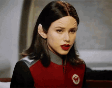 a woman is wearing a red jacket with a white circle on it