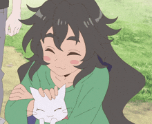 a girl with long black hair is petting a small white cat