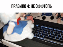 a stuffed animal is sitting in front of a keyboard with russian writing on it .