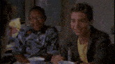 a group of people are sitting at a table talking to each other .