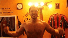 a shirtless man flexes his muscles in front of a wall that says " the pain "