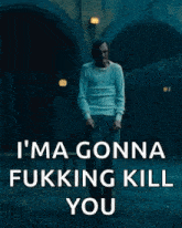 a man in a white shirt is standing in front of a building with the words `` i 'm gonna fucking kill you ''