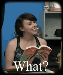 a woman is reading a book and smiling with the words what on the bottom right