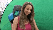 a woman is sitting in a clutch chair and smiling