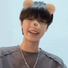 a young man wearing a necklace and a teddy bear mask on his face .