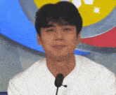 a man in a white shirt with a microphone in front of him