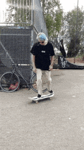 a person with blue hair is riding a skateboard in front of a fence that has the letter y on it