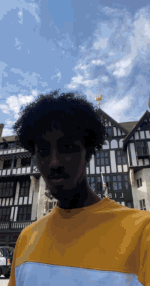 a man in a yellow shirt stands in front of a building that says ' liberty ' on the front