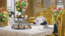 a woman in a white dress sits at a table with cupcakes on it