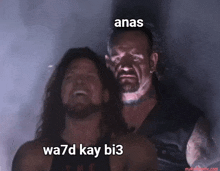 two wrestlers are standing next to each other with the words anas wa7d kay bi3