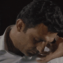 a close up of a man 's face with his hands on his face