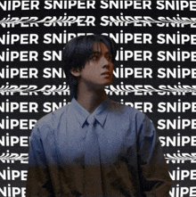 a man in a blue shirt and tie stands in front of a black background that says sniper