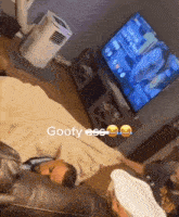 a man is laying on a couch in front of a tv that says goofy ass