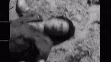 a black and white photo of a person laying on the ground