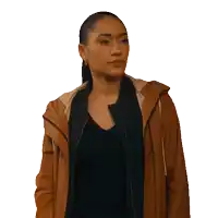 a woman wearing a brown jacket and black shirt