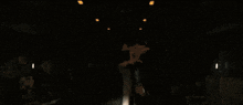 a man in a dark room with a white shirt on