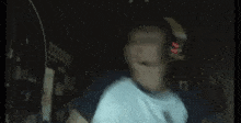 a man wearing headphones and a headset is dancing in front of a computer screen .