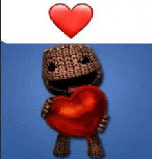 a stuffed animal is holding a red heart in his hands