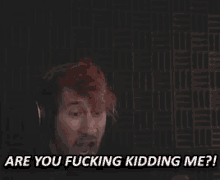 a man wearing headphones is screaming and saying `` are you fucking kidding me '' .