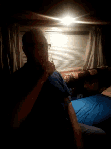 a man with glasses is laying on a bed