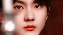 a close up of a young man 's face with red lips