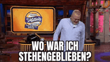 a man is standing in front of a sign that says wo war ich stehengeblieben ? .
