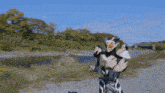 a man in a superhero costume is standing on a dirt road