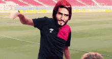 a man wearing a new balance shirt is standing on a field
