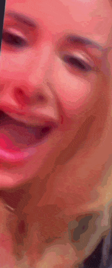 a close up of a woman 's face with her mouth open and a blurry background .