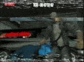 a video of a man sitting in a car with a red sign that says ' valiant video ' at the bottom